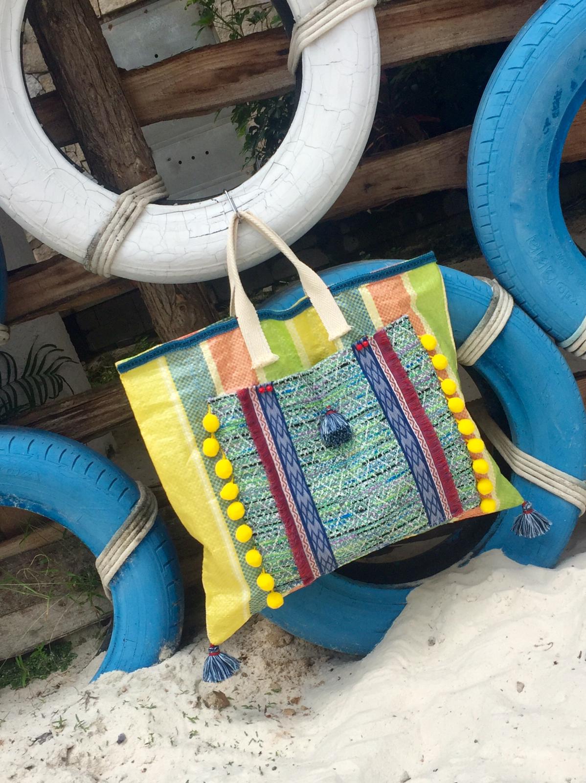Bolso de plástico reciclado, decorada con telas, pasamanerias y borlones de diferentes colores
