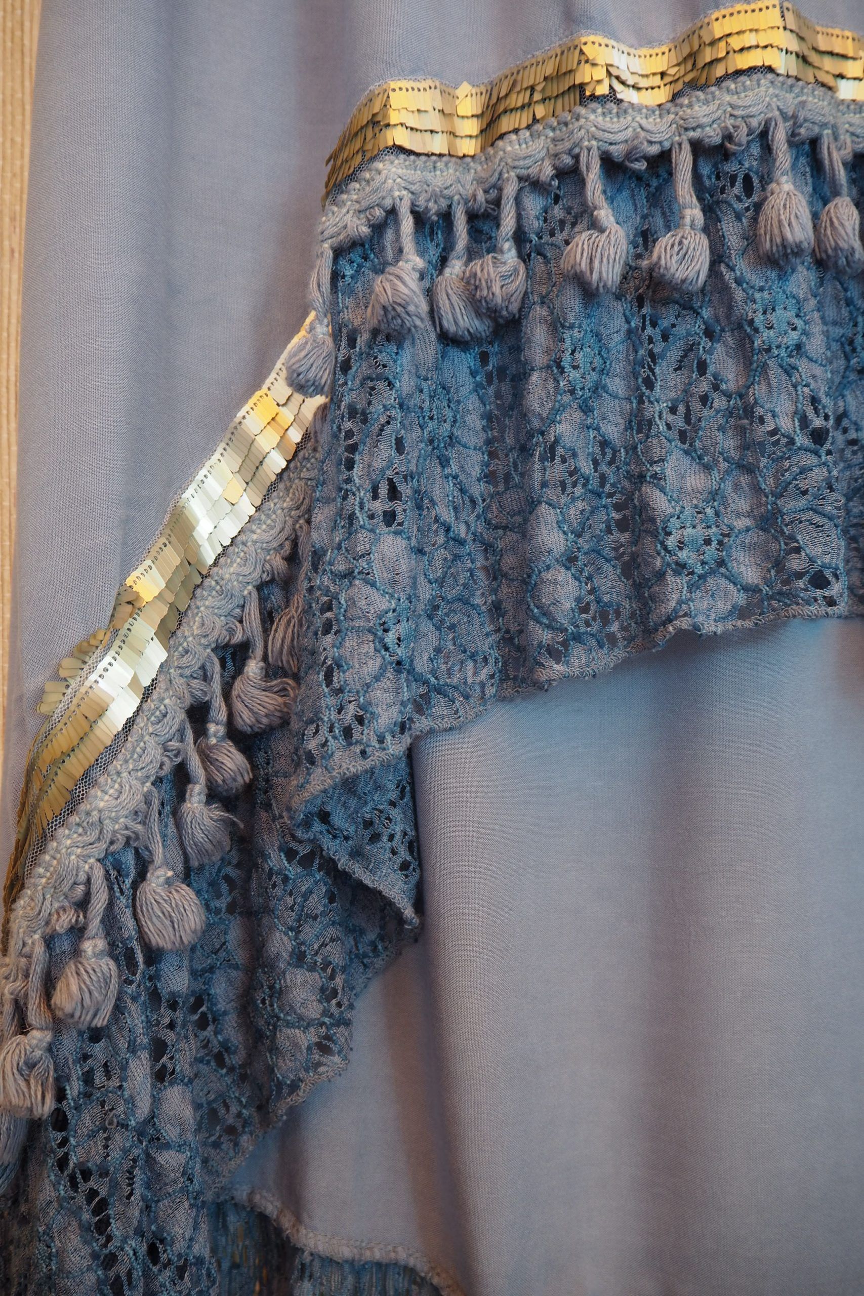 Falda de largo desigual celeste con volante de encaje y borlones con pallet plateados