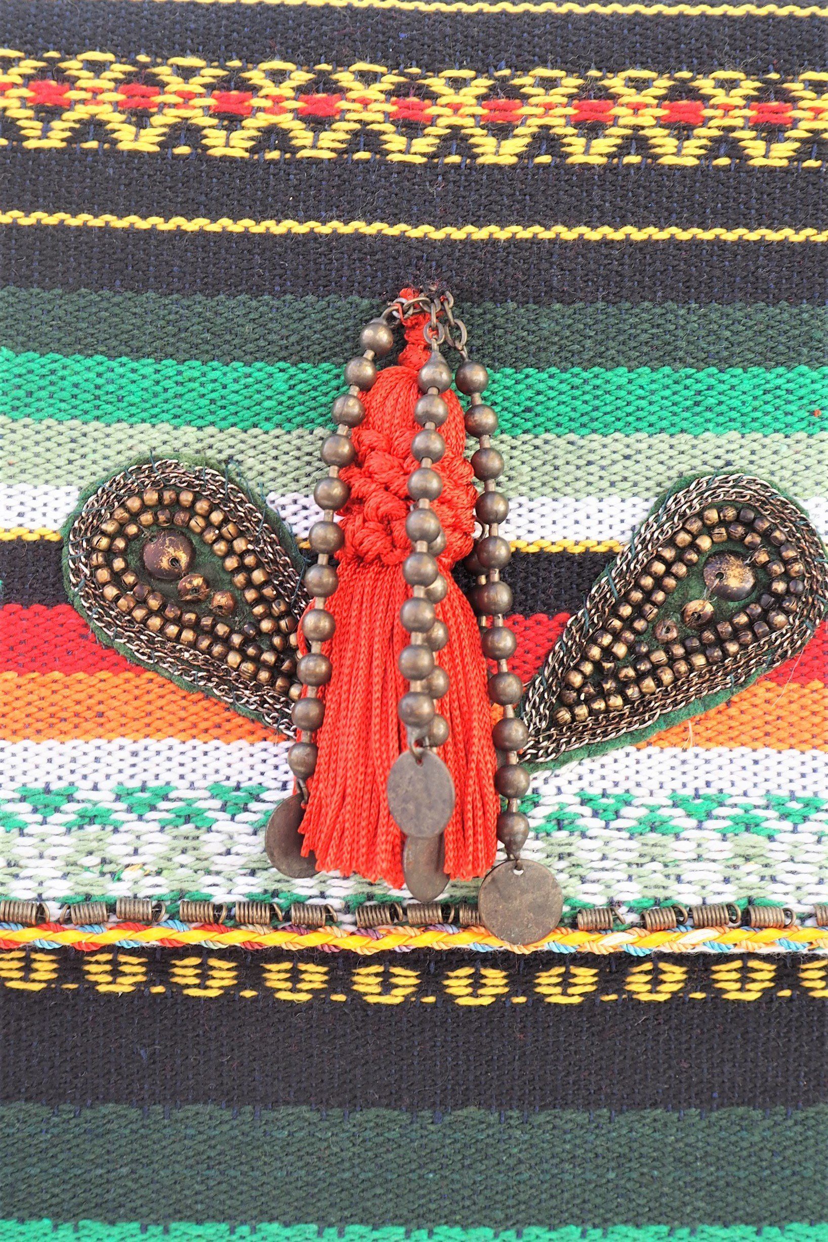 cartera de mano de estilo étnico en tonos vivos y decorado con borlón y abalorios