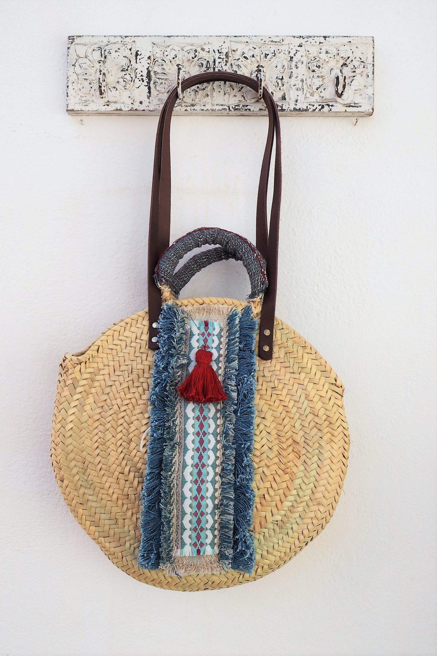 bolso capazo trenzado de palma decorado en tonos azul y rojo