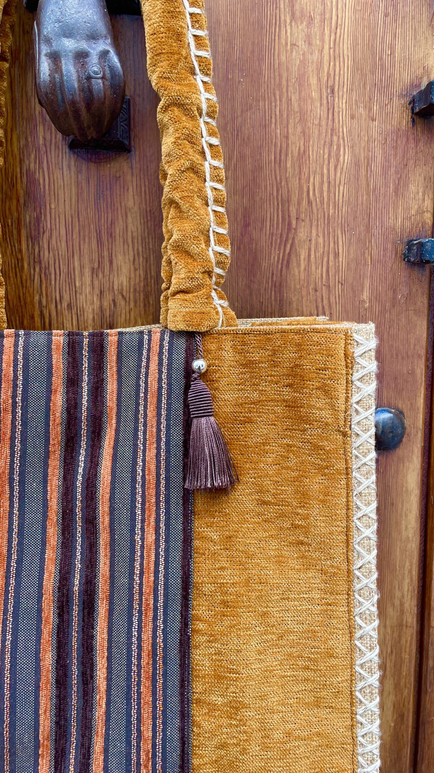 Bolso con detalles étnicos como borlones y pasamanería