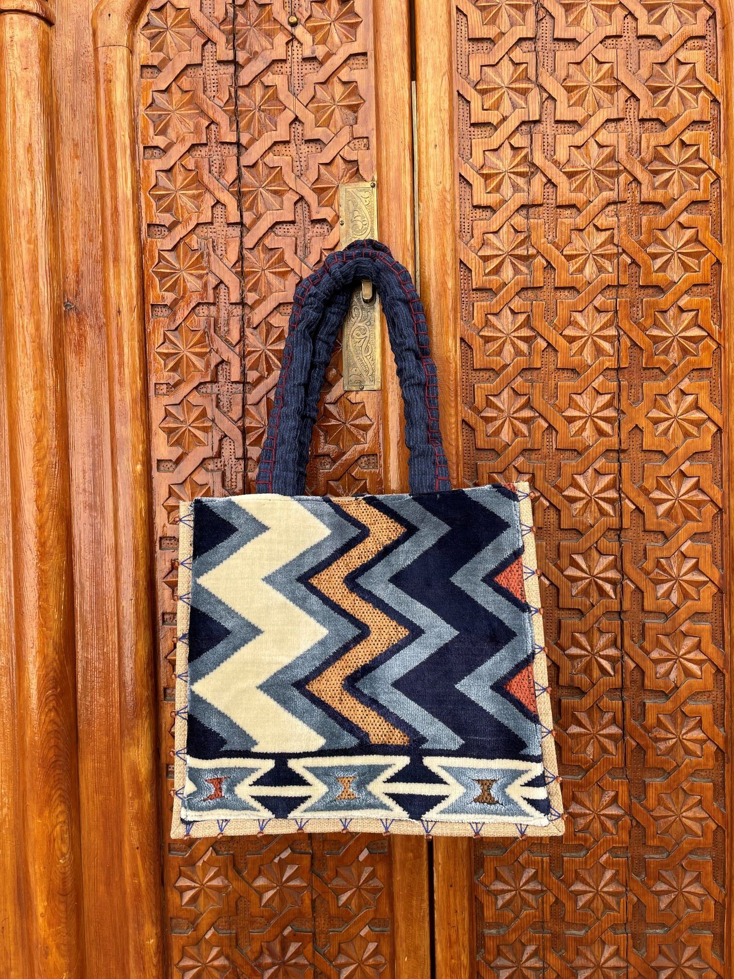bolso boho diseñado con alfombra en tonos azules y tostados